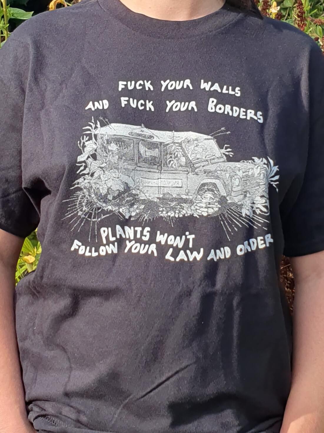 T shirt design depicts a police car being overgrown with weeds, with the words 'Fuck your walls and fuck your borders, plants won't follow your law and order'.